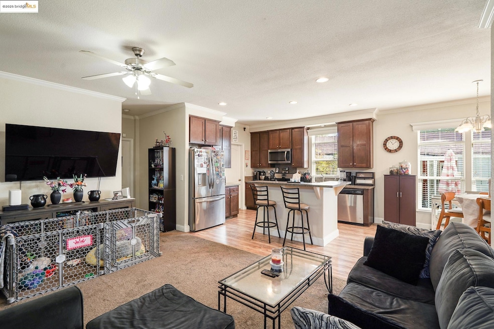 Living area featuring ornamental molding, recessed lighting, light wood-type flooring, ceiling fan, and a chandelier