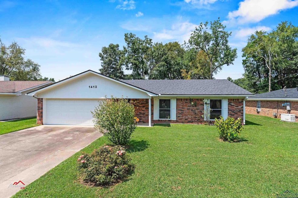 Ranch-style home featuring a garage and a front ya