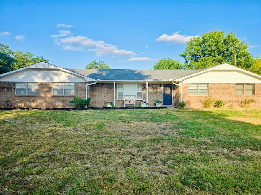 Ranch-style house with a front yard and brick siding