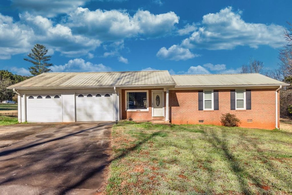Ranch-style home with a front lawn and a garage