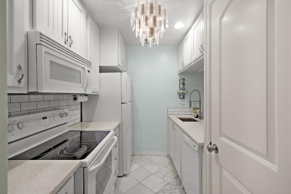 Kitchen with light countertops, white appliances,