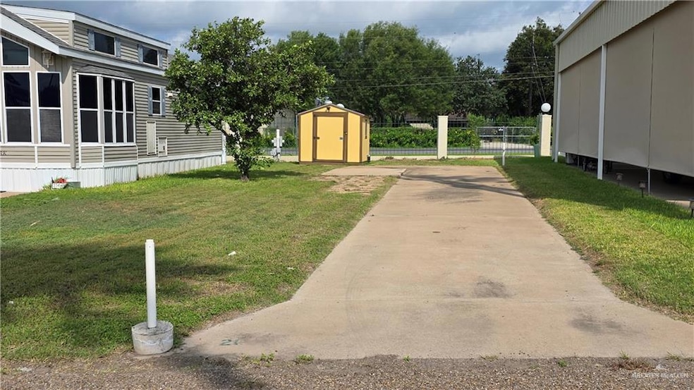 View of lot featuring a storage shed and concrete driveway