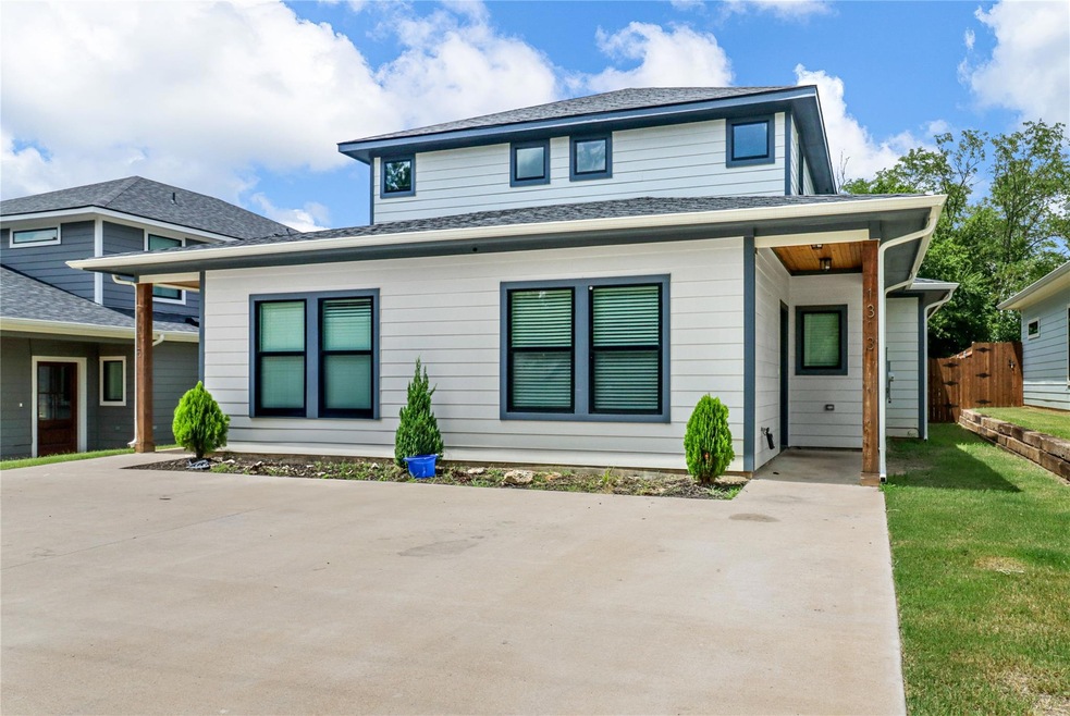 View of front facade with driveway, a shingled roo