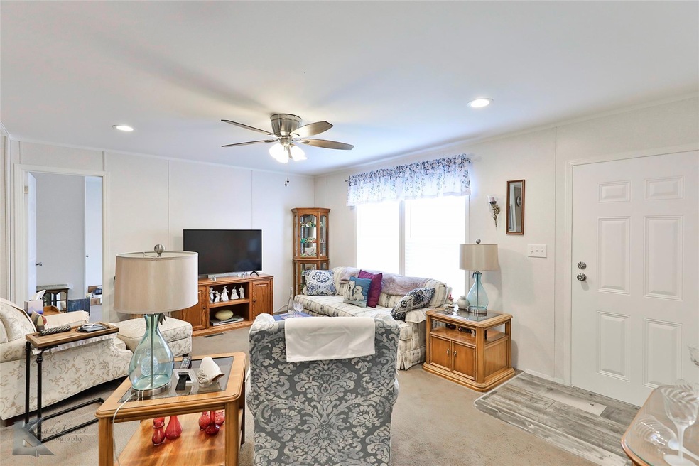 Living room featuring ceiling fan and light carpet