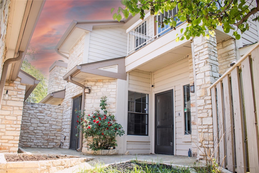 Entrance to property with stone siding and a balc