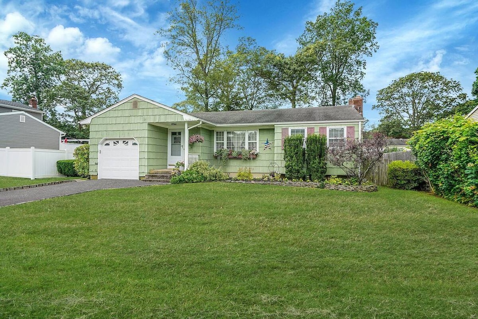 Single story home with an attached garage, asphalt driveway, and a chimney