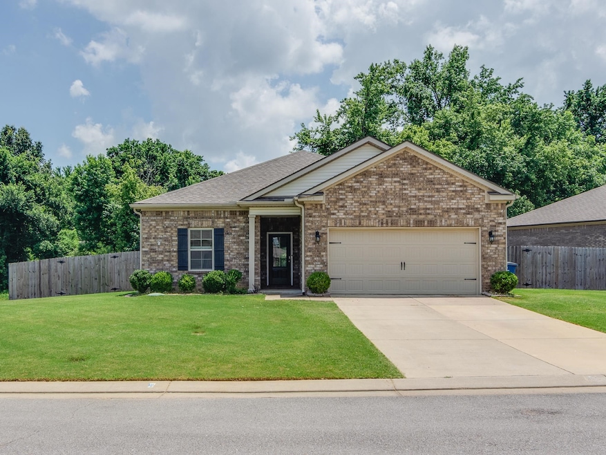 View of front facade featuring an attached garage, brick siding, concrete driveway, and roof with shingles