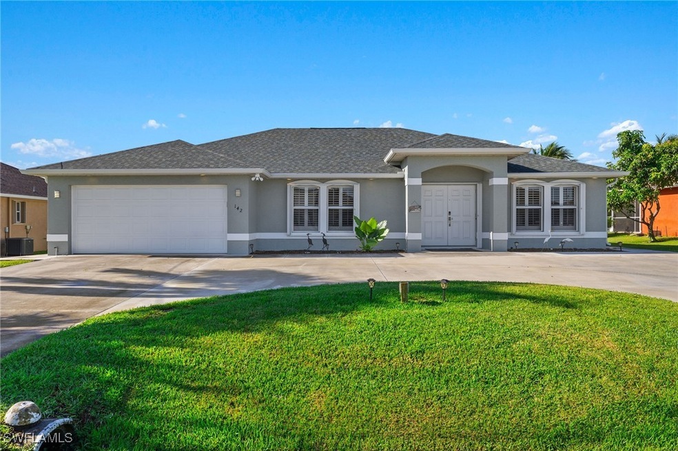 View of front of property featuring a garage, central AC, and a front yard