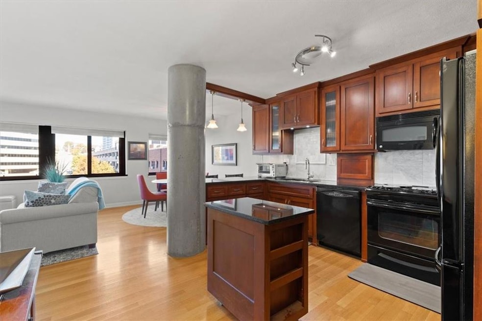 The open layout features hardwood floors and a wall of windows