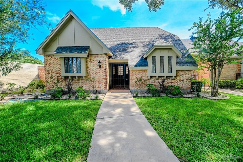 View of front of property with a front lawn, brick siding, and a shingled roof