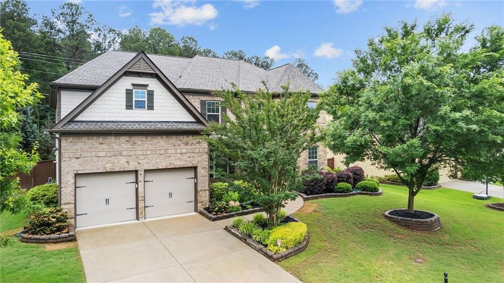 View of front of property with a front yard, driveway, an attached garage, a shingled roof, and brick siding