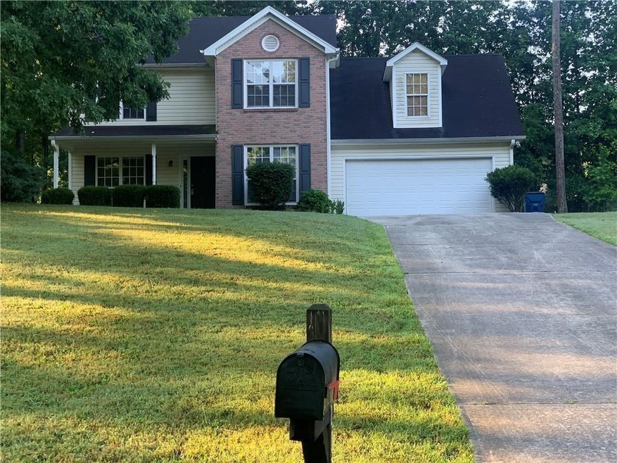 View of front of home with a front yard, an attached garage, and driveway