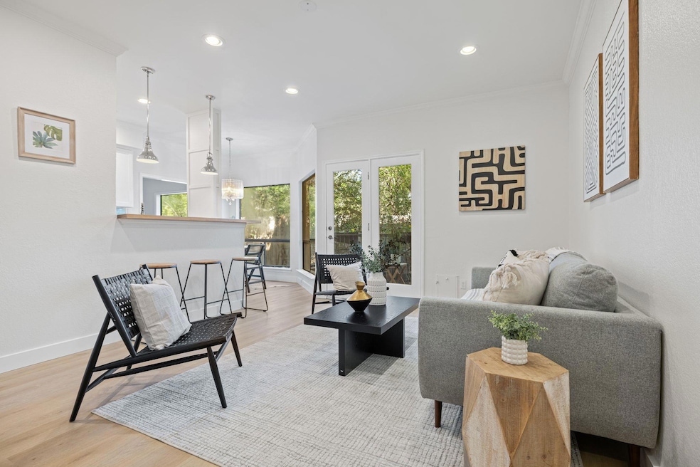 Living room featuring crown molding, wood finished floors, recessed lighting, and french doors