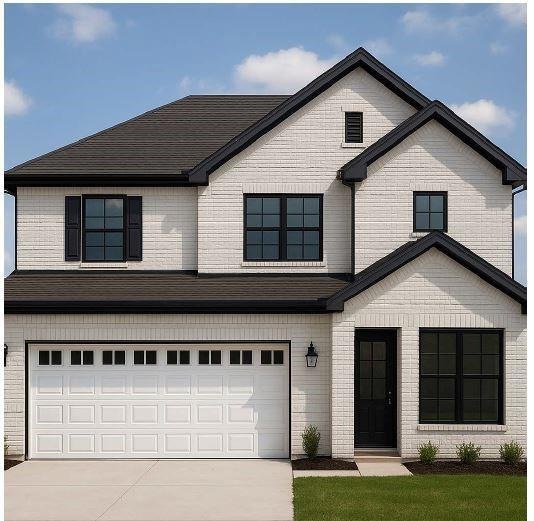 View of front facade with an attached garage, driveway, and brick siding