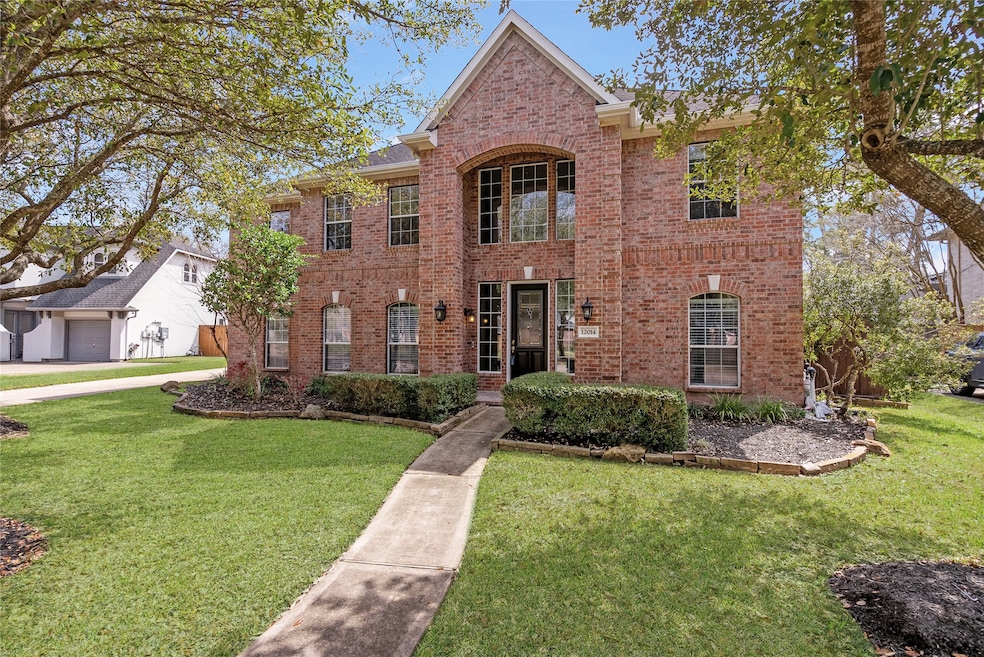 Elegant front elevation framed by mature Oak trees