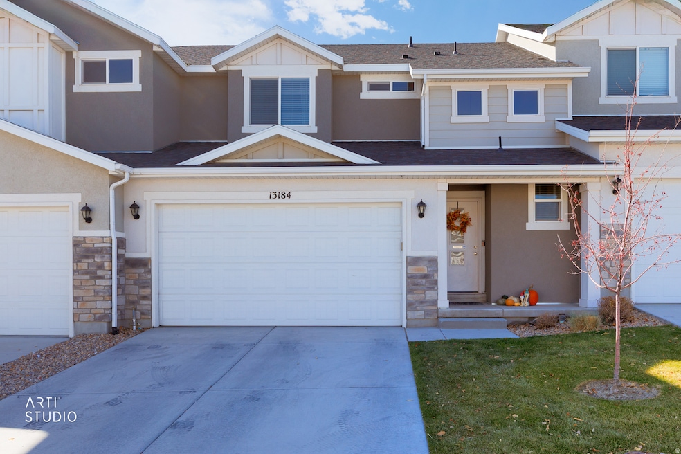 Modern townhome with stone siding, concrete driveway, and covered porch