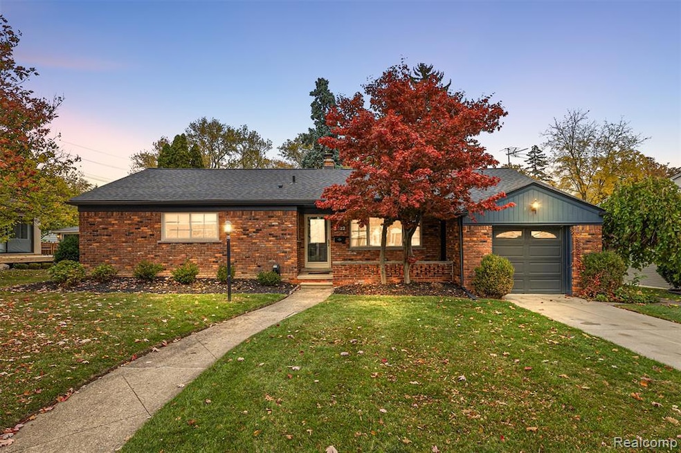 Single story home featuring a front yard, an attached garage, brick siding, and roof with shingles