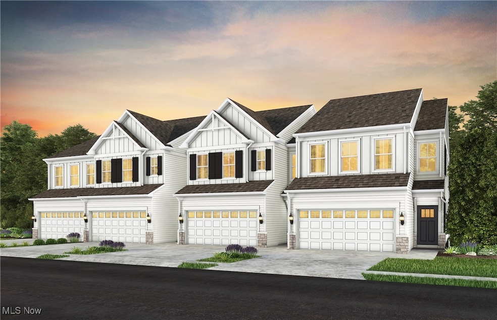 Modern farmhouse style home with board and batten siding, a garage, driveway, and stone siding