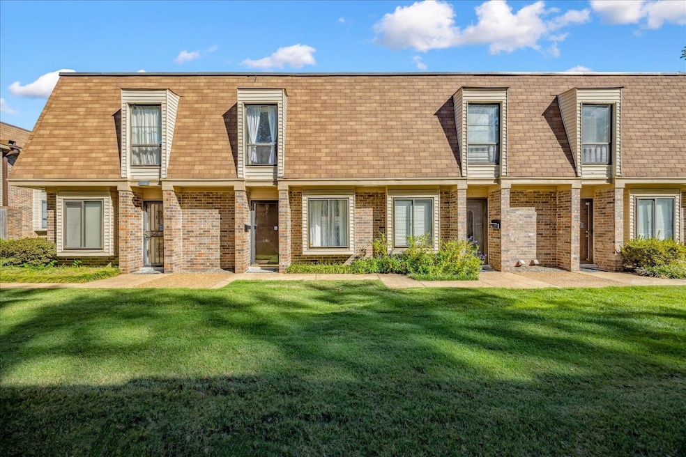 Rear view of house featuring mansard roof, a yard, and a shingled roof