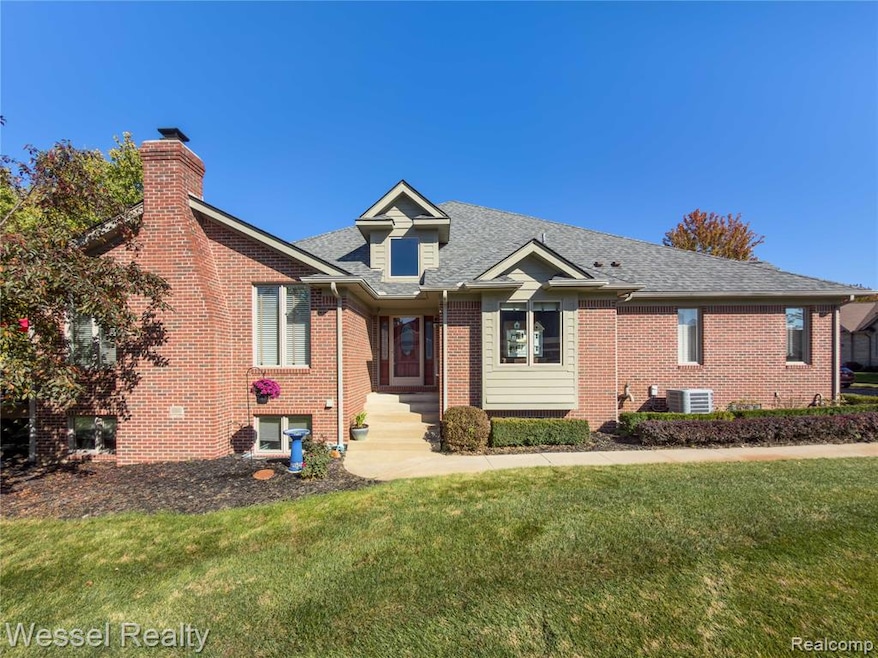 Single story home featuring a front yard, brick siding, a chimney, and roof with shingles