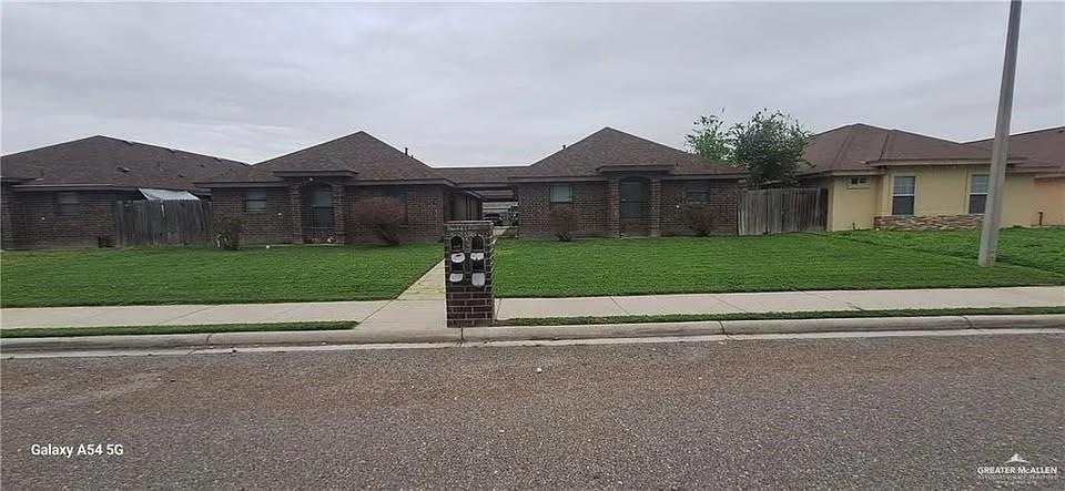 View of front of home with a front lawn and fence