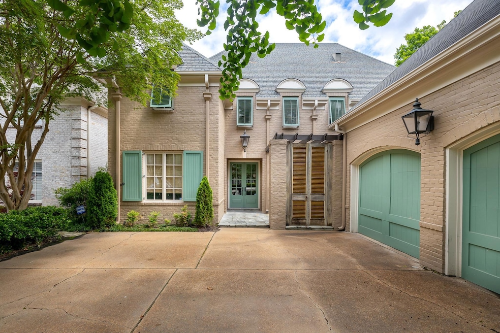French country style house with french doors, driveway, brick siding, and a shingled roof