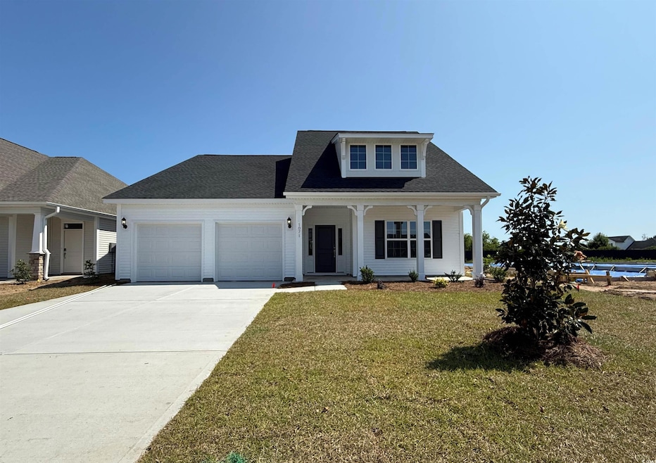 View of front of property featuring covered porch, a garage, a front lawn, driveway, and roof with shingles