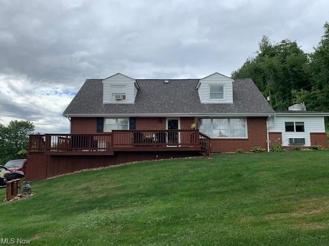 Rear view of property featuring a yard and wooden 
