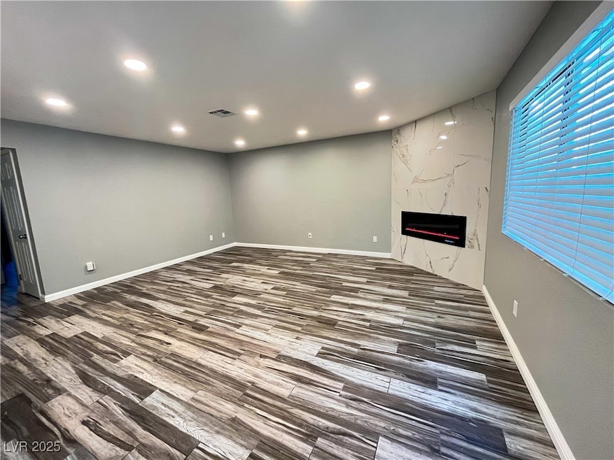 Unfurnished living room with a fireplace, recessed lighting, and wood finished floors