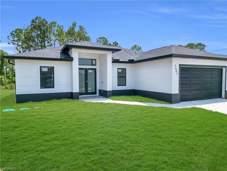 View of front facade featuring french doors, an attached garage, a front lawn, and a shingled roof