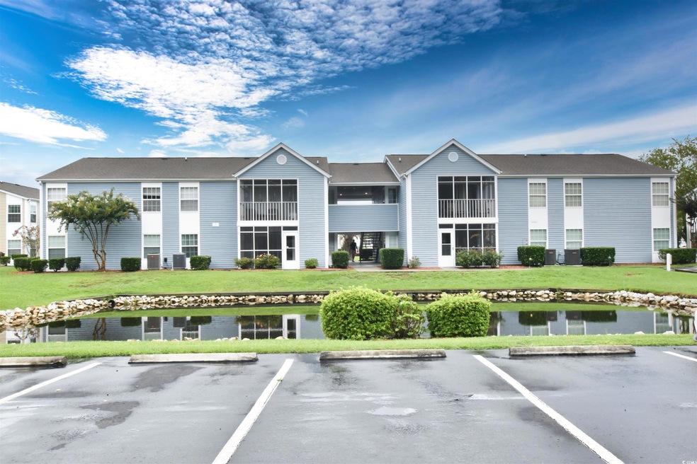 View of property featuring a water view and uncovered parking