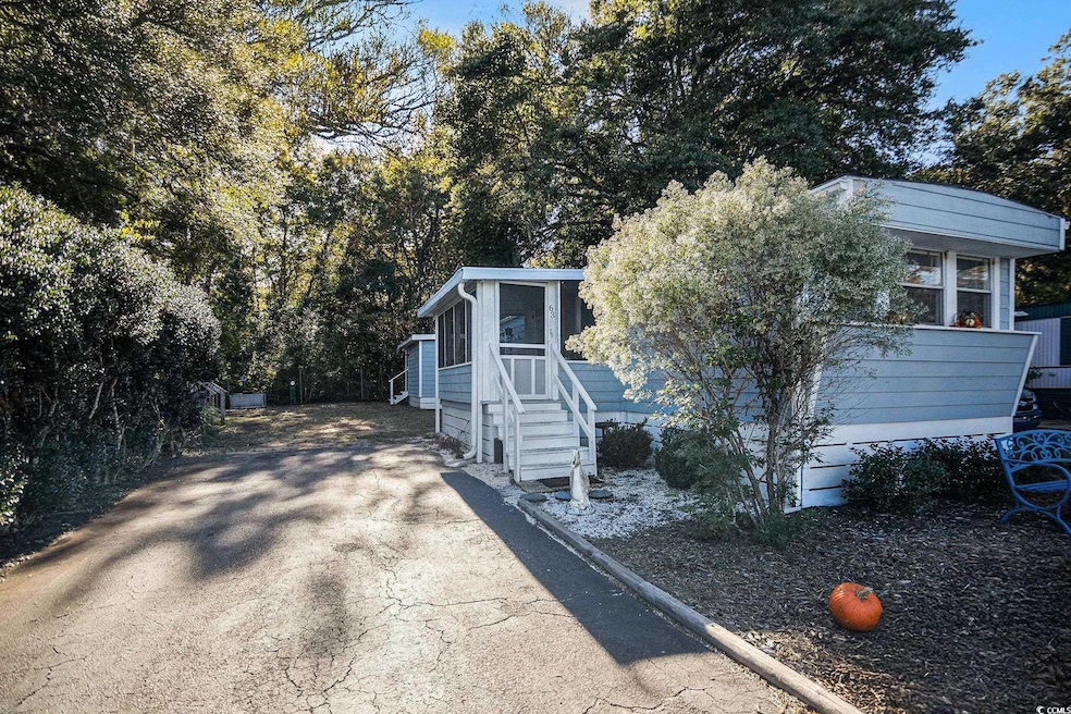 View of front of property featuring a sunroom and driveway