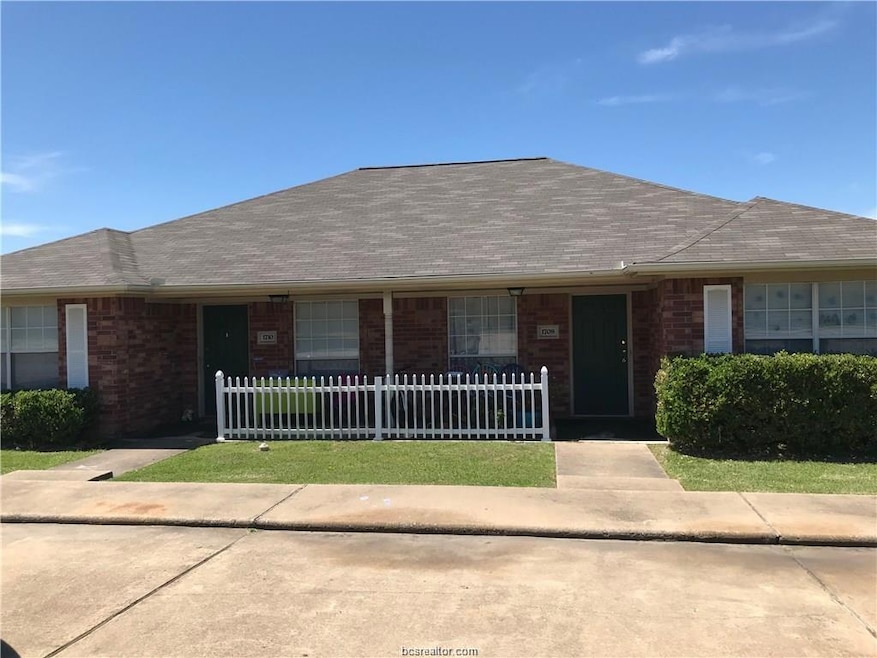 Single story home with a fenced front yard, brick