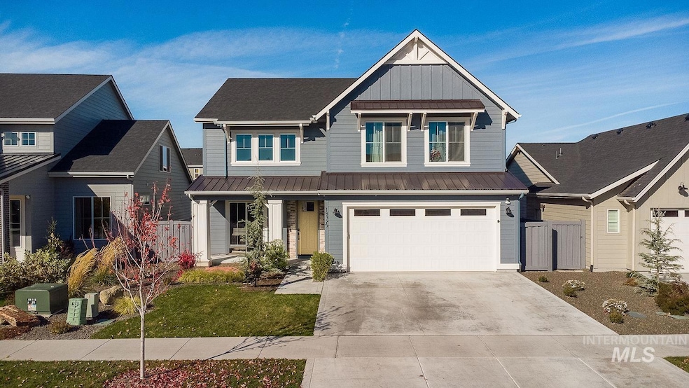 Craftsman inspired home featuring board and batten siding, covered porch, a metal roof, driveway, and a standing seam roof