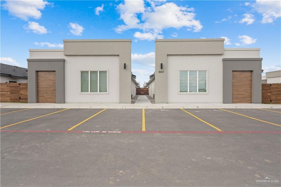 View of building exterior with uncovered parking and fence
