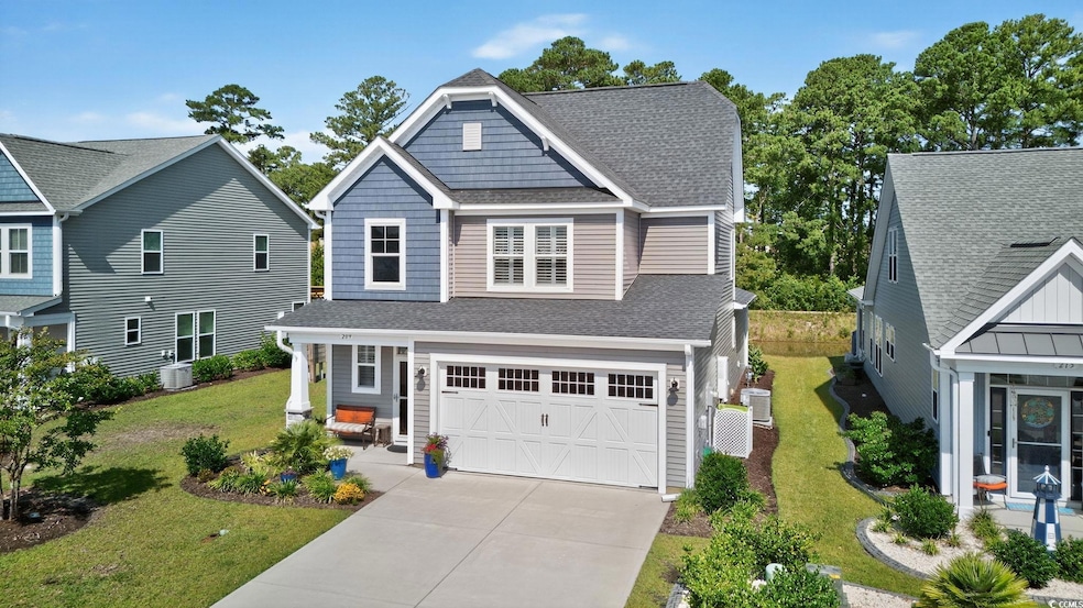 Craftsman inspired home featuring a shingled roof, an attached garage, driveway, and a front lawn