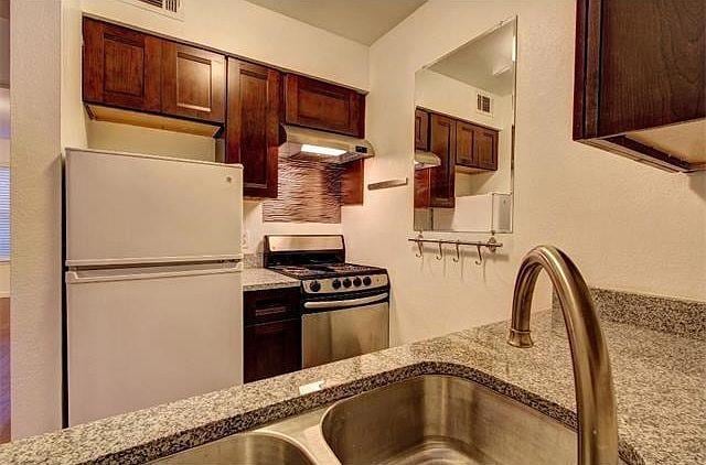 Kitchen with freestanding refrigerator, gas range