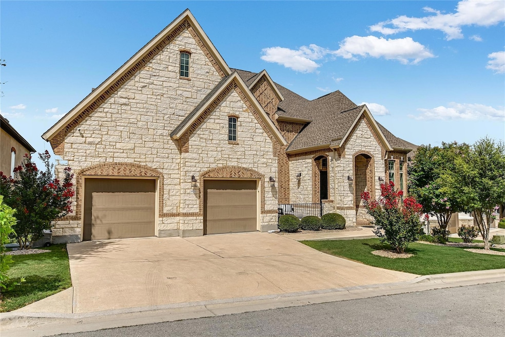 French country inspired facade with stone siding, driveway, a front yard, and roof with shingles