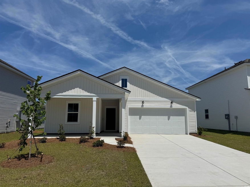Single story home with covered porch, an attached garage, driveway, and a front yard