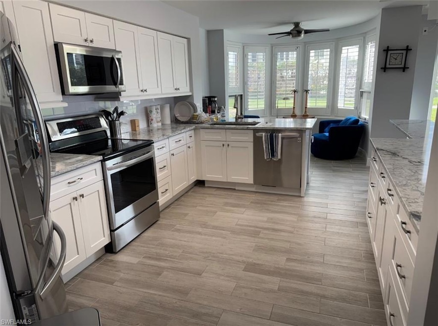 Kitchen with a peninsula, a sink, appliances with 