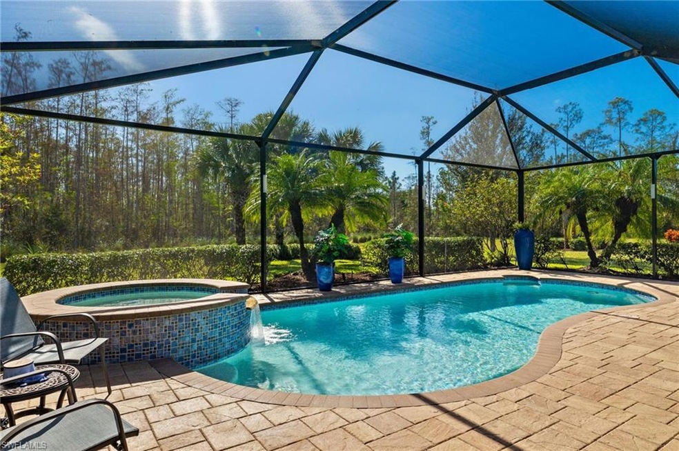 View of pool with glass enclosure, an in ground ho