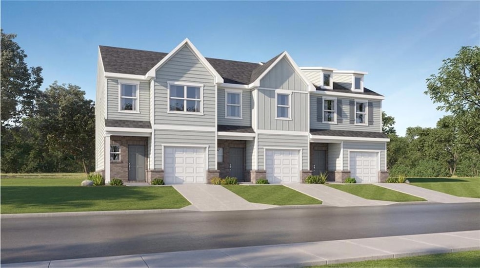 View of property featuring a front lawn, stone siding, board and batten siding, and a garage