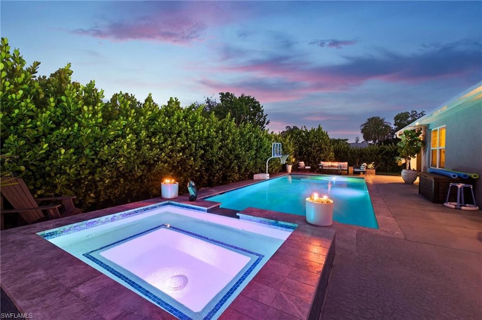 Pool at dusk with an in-ground hot tub, a patio, an outdoor pool, and a fire pit