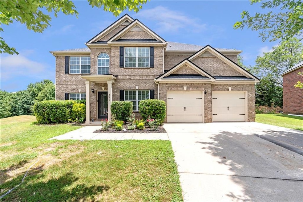 View of front of house with brick siding, concrete driveway, a front lawn, and an attached garage