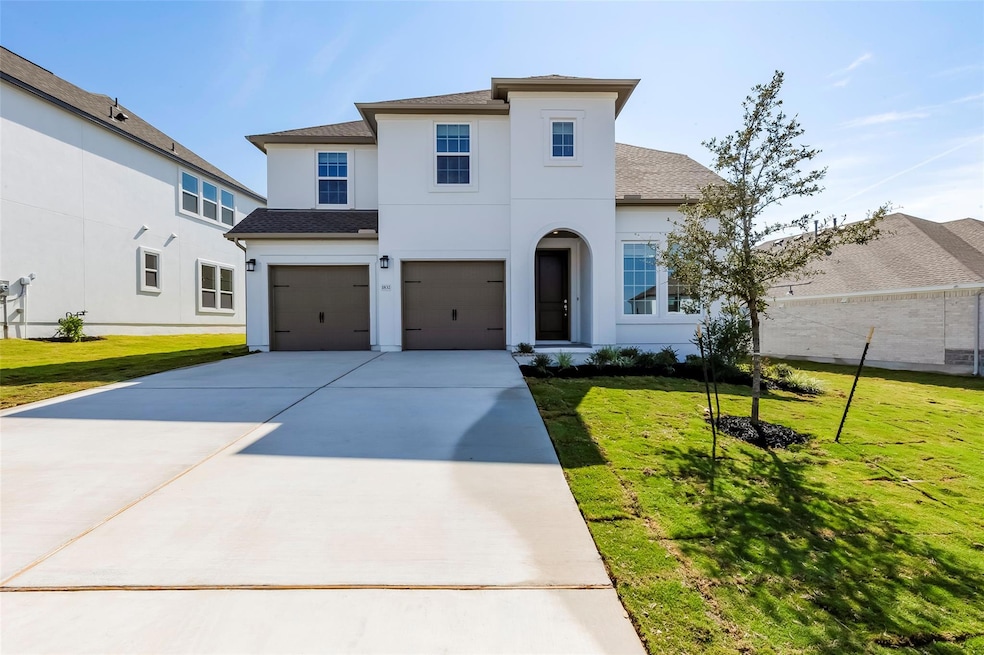 View of front facade featuring roof with shingles, a front lawn, concrete driveway, and an attached garage