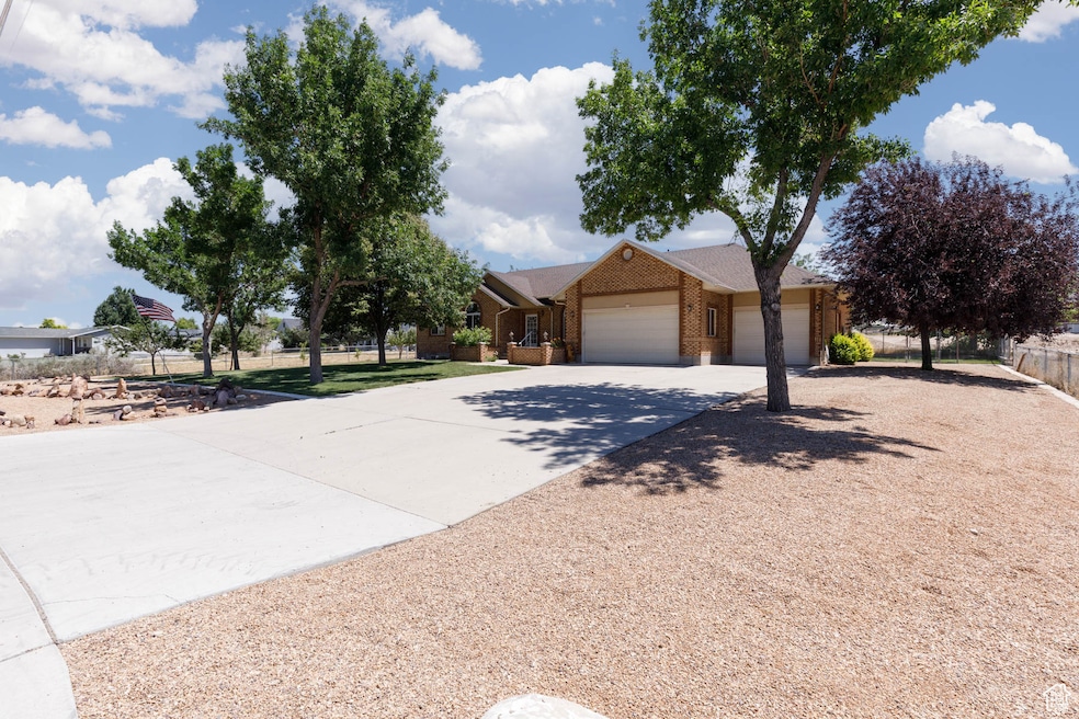 View of front of property featuring an attached garage, driveway, and brick siding