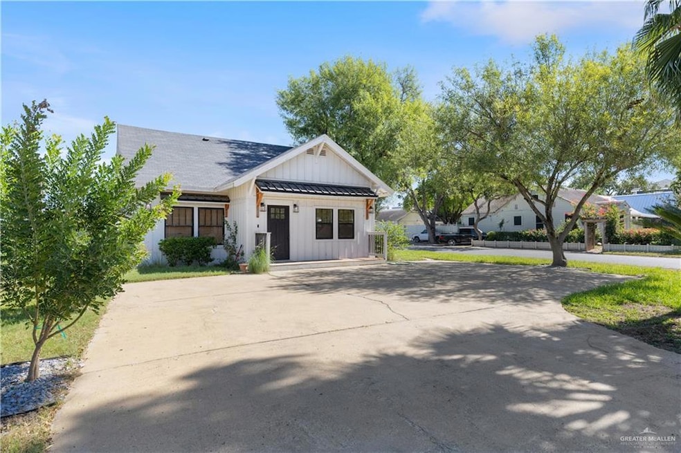 View of front of property with board and batten siding, a standing seam roof, a metal roof, and concrete driveway
