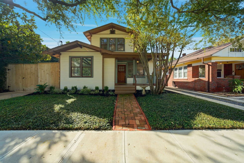 Charming craftsman style two-story home with a welcoming front porch and a well-maintained yard. Features a brick walkway, mature trees, and a classic design, perfect for comfortable living.