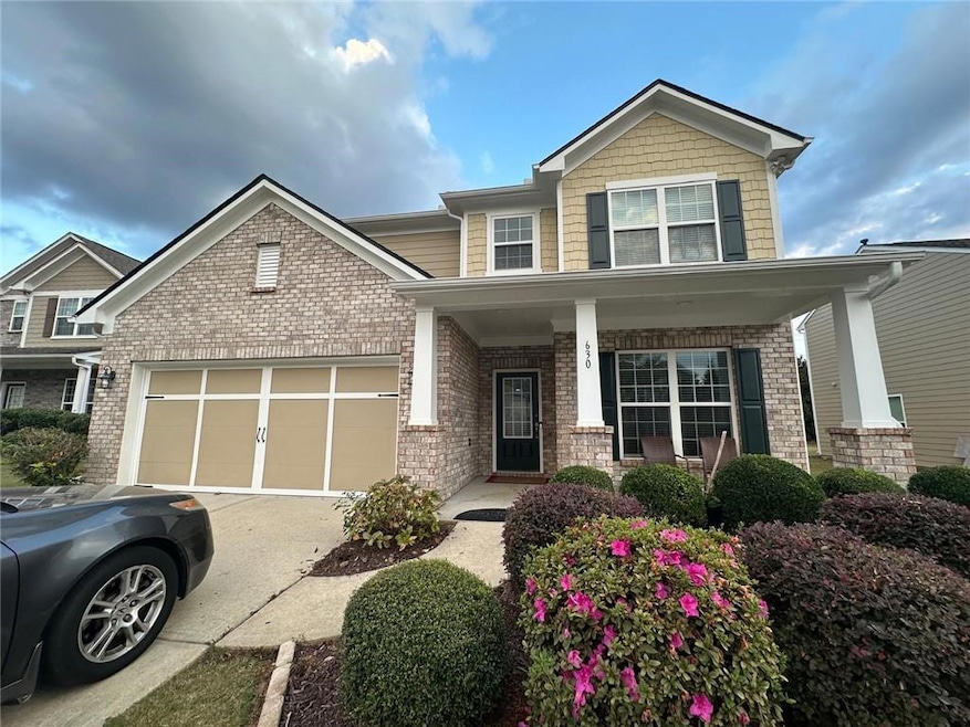 Craftsman-style house featuring concrete driveway, covered porch, an attached garage, and brick siding