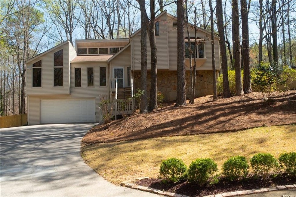 View of front of property featuring driveway, ston